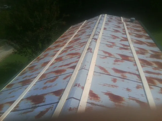 Rusted metal roof panels with new wood purlins before replacement — Storm Damage Roof Repair in Barnum by Roofing Brothers