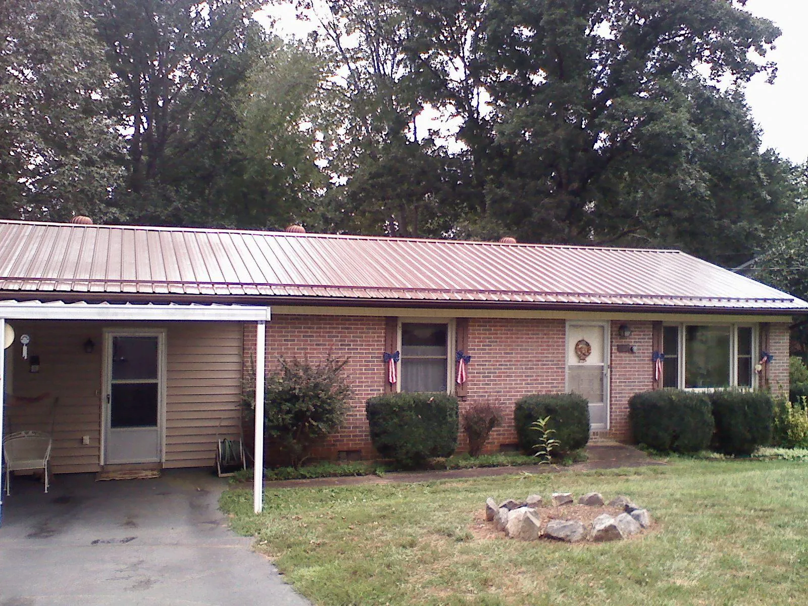 Bronze metal roof and carport on a brick ranch home — Roof Repair work by our crew in Barnum